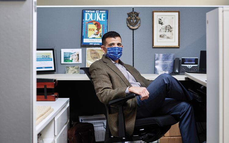 Randy Garcia prefers coming into the office, where he can work from his cubicle at One City Center in downtown Durham. Photo by Alex Boerner.