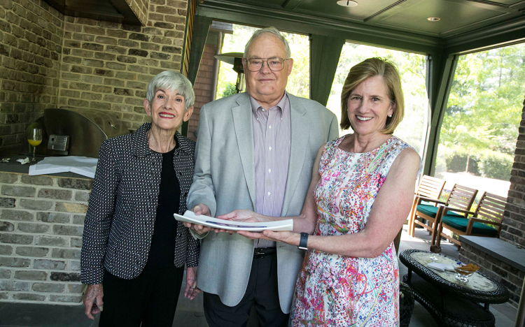 Dean Mary Klotman, right, presents Dudley and Michele Rauch with a gift celebrating a milestone in their philanthropic support for Duke University School of M