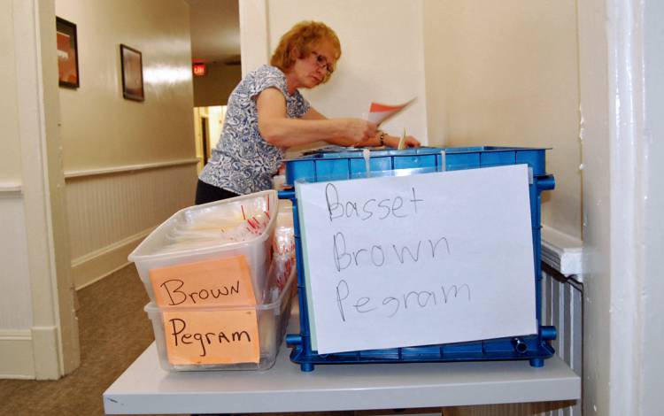 Residence Life Staff Assistant Sherry Reynolds grabs keys for students checking in to their East Campus residences.