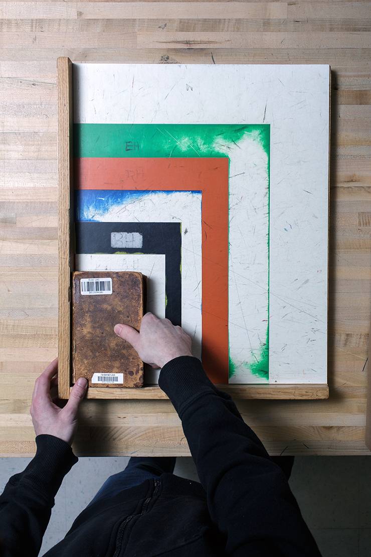 Returned books are sorted by size using a colorful, well-worn guide. Photo by Alex Boerner.