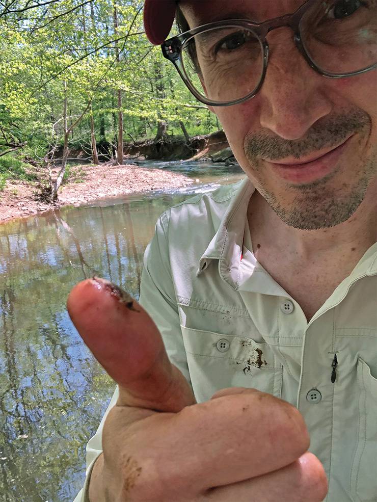 Associate in Research Steven Anderson shows off a stonefly in Duke Forest. Photo: Steven Anderson.