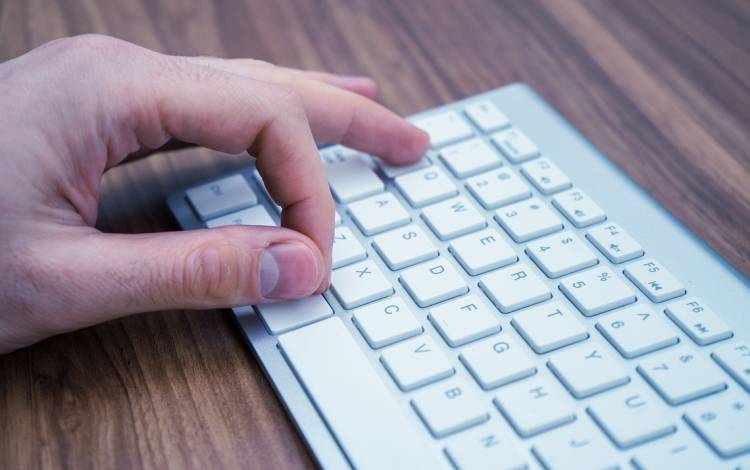 Hands typing on a keyboard.