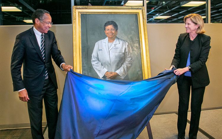 Dr. Eugene A. Washington, left, and Dr. Mary E. Klotman, unveil the portrait of Brenda Armstrong that now hangs in the admissions office before the pandemic. Photo courtesy of Duke School of Medicine.