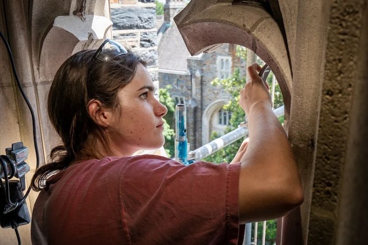 Carolina Goldkuhle works on the stone tracery that held the stained glass in place in Duke Chapel’s Narthex.