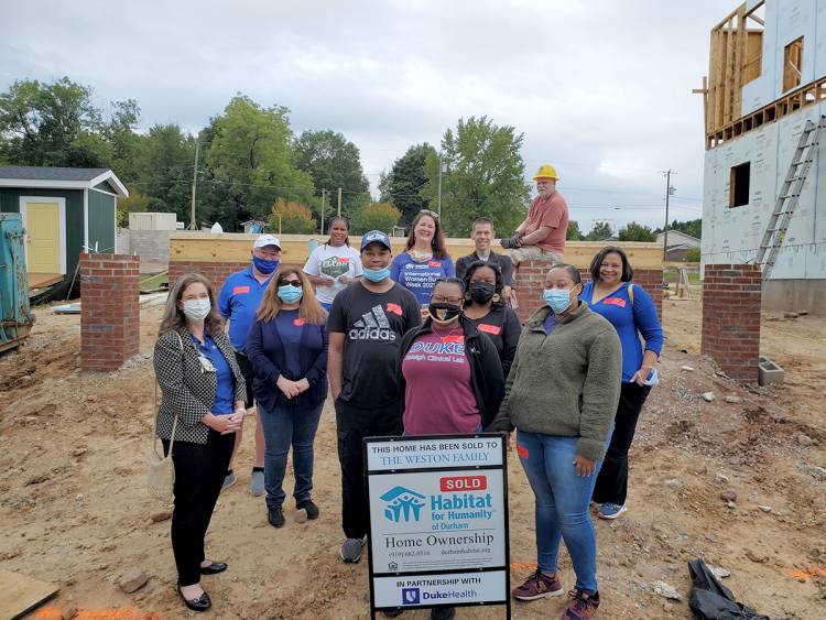 Volunteer workers pose on the location of the Habitat house