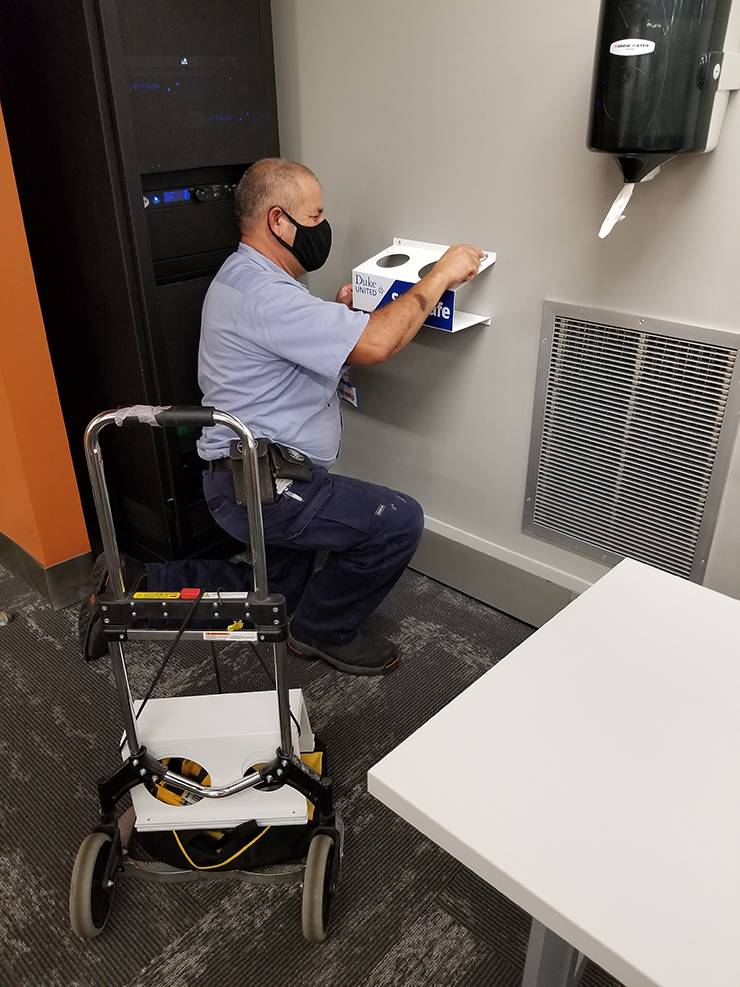 General Maintenance Mechanic Silvio Guardado installs a Classroom Caddie. Photo courtesy of Duke Facilities Management.