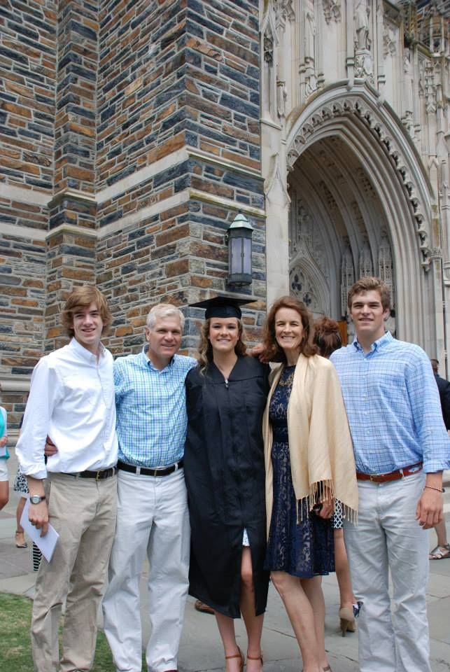 Caralena (centre, in cap and gown) poses with her family on graduation day in front of the Duke's Chapel. 