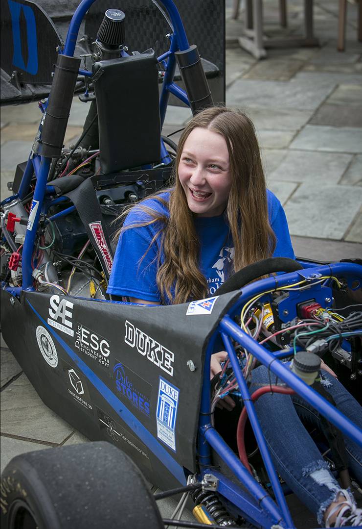 Little River K-8 eighth grader Grace Herbstreith, 13, gets a kick out of the Duke Motorsports engineering race car in front of CIEMAS during Duke-Durham School Days. Photo by Jared Lazarus.