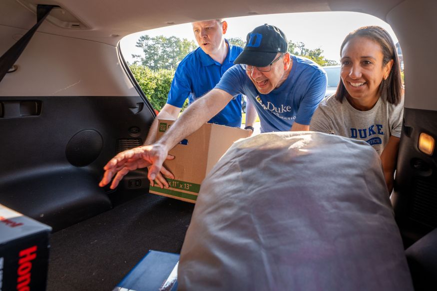 Ed Balleisen reaches deep into a trunk as Jerome Lynch and Nina King pick up items from the edge