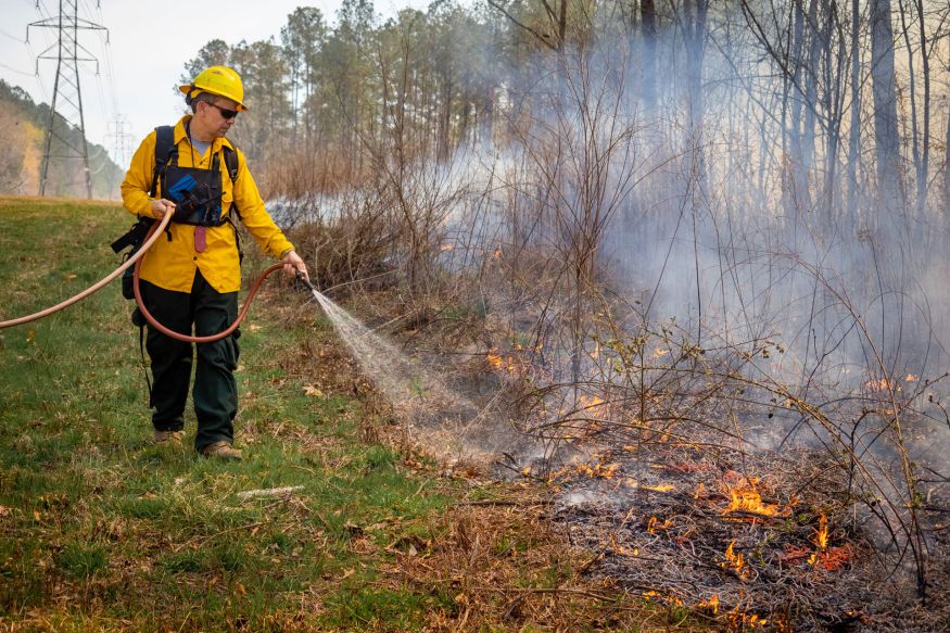 Tom Craven spraying the edge of the fire with water