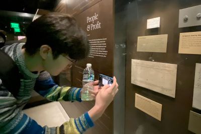 Sangwook Cheon records a ship manifest at the National Museum of African American History and Culture connected to the transportation of an enslaved young girl away from her family. This led to a discussion about what stories the enslavers, their families and friends told themselves about how it would be okay to do such harm and injury to children and families. Photo by Catherine Admay.