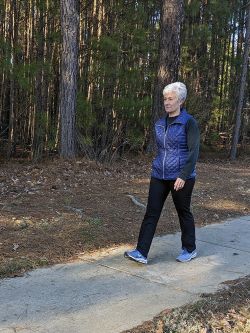 Franca Alphin walks on a path near the woods