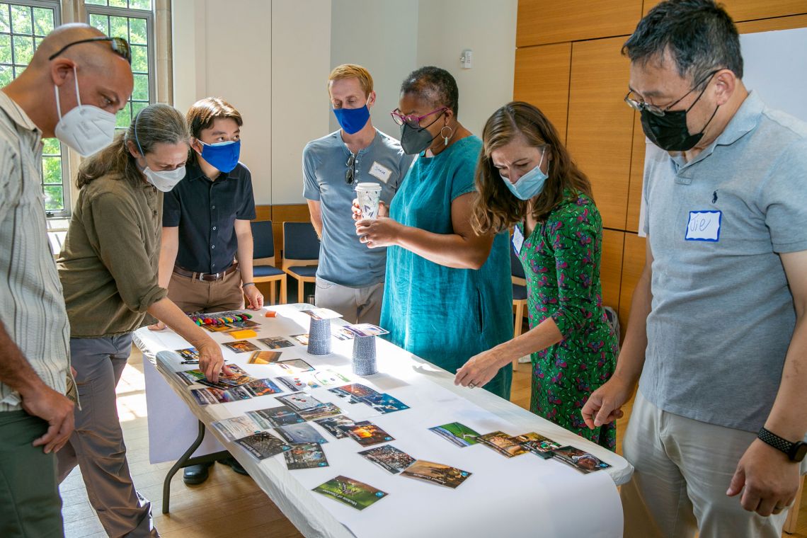 Duke climate change faculty fellows become familiar with a climate change board game that will be part of the course.