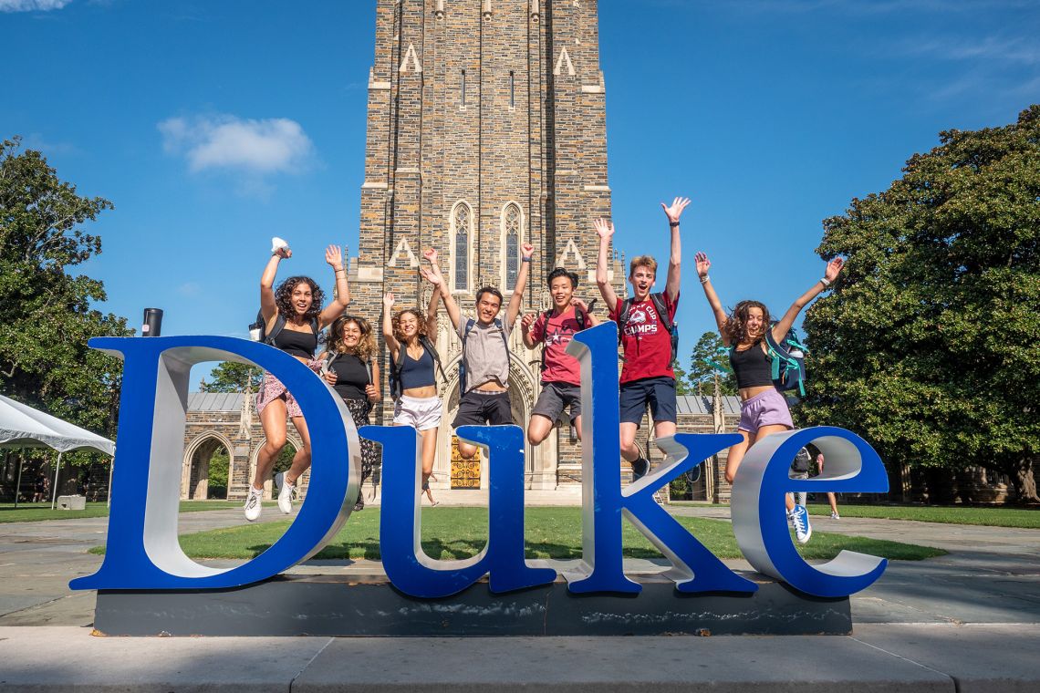 Students jump behind the Duke sign on the first day of classes. (Bill Snead/Duke University Communications)