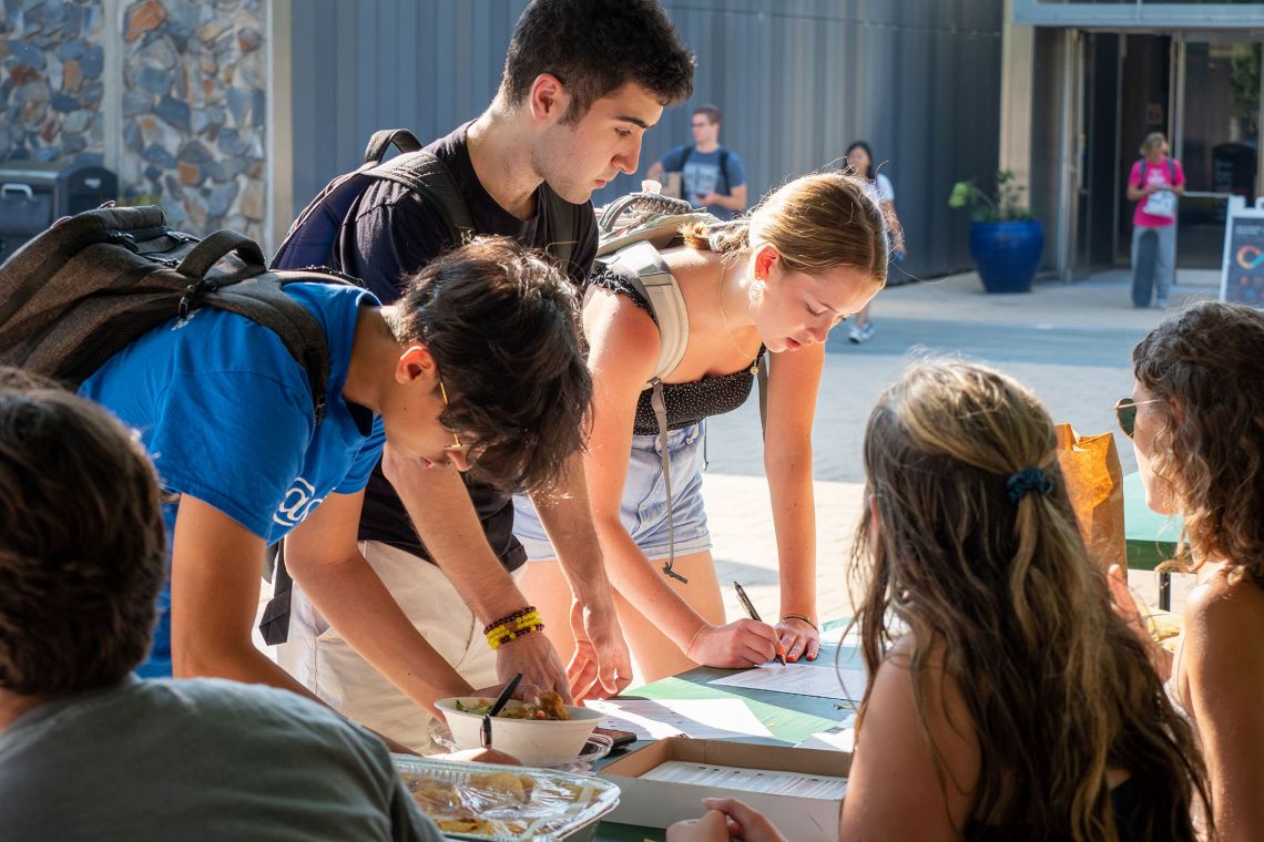 Students register to vote at a registration table on the Plaza. 