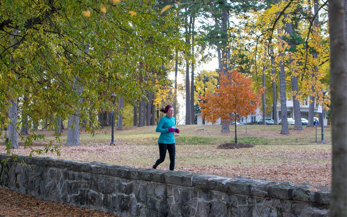 A runner jogs along the East Campus wall.
