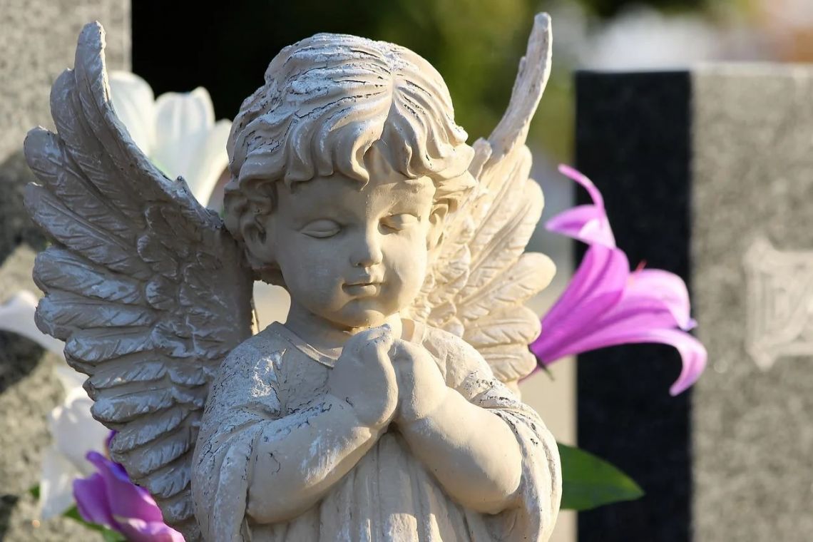 statue of a baby angel in. a cemetery