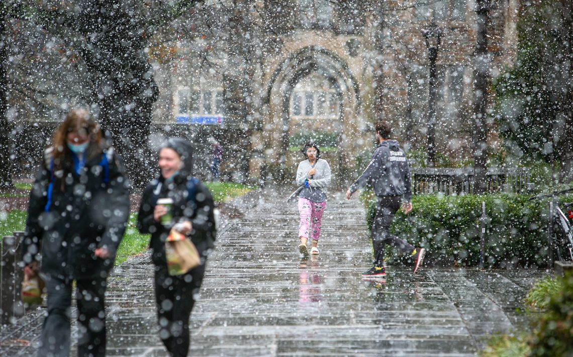 photo of people walking through the snowfall on West Campus