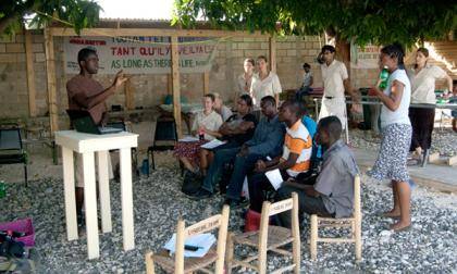 DukeEngage student Sedlin Mirtil presents summer projects to the Haitian staff at Johanniter International. 