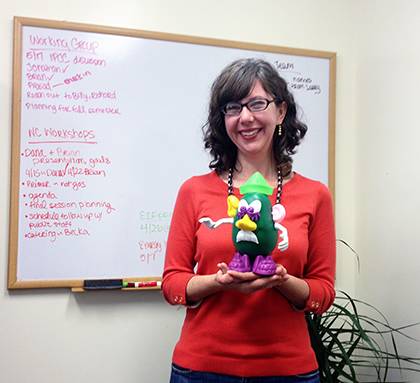 Emily Schieffer, a senior policy associate in the Nicholas Institute's Ecosystem Services Program, poses with a green Mr. Potato Head. The figure is used by the office as a way to instill sustainable behaviors. Photo courtesy of Erin McKenzie.