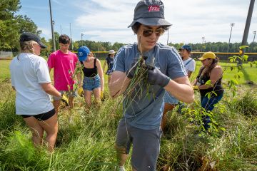 First-year students spent a morning at Durham’s Southern School of Energy and Sustainability mulching tree beds and creating protection for new tree plantings. (Bill Snead/University Communications)