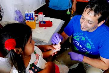 Ernesto Ortiz chats with a young girl in the Peruvian Amazon during a health check.
