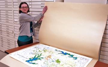 Duke University Archives Records Manager Hillary Gatlin shows off a map of Duke Forest recently transferred to the archives. Photo by Stephen Schramm.