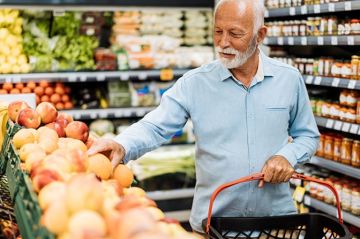 older man buying fruit in grocery store