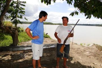 Duke researcher Ernesto Ortiz talks with a hunter in the Madre de Dios region of Peru.