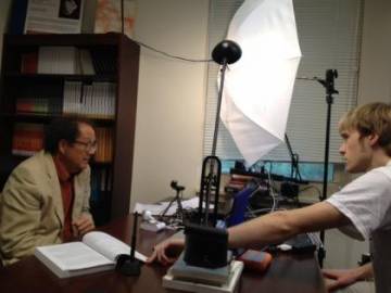 Duke professor Walter Sinnott-Armstrong, (left), records a Coursera lecture in his cramped office, which for months was used as a recording studio. A student, Joe Metz, (right), helps with video editing.