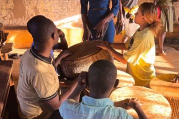Lihua Mo-Hunter plays drums in Uganda